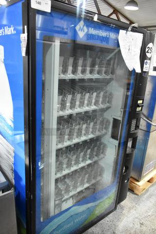 Metal commercial vending machine with bill acceptor, branded Member's Mark. Features multiple shelves and large glass front.