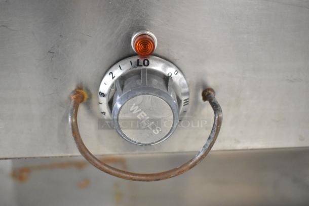 Duke Aerohot EP304 steam table control knob, marked "WELLS," with temperature settings and a warning light.