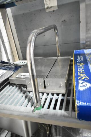 Metal countertop cheese cutting station with dual handles and stainless steel surface. Tag marked "156". Ideal for commercial use.