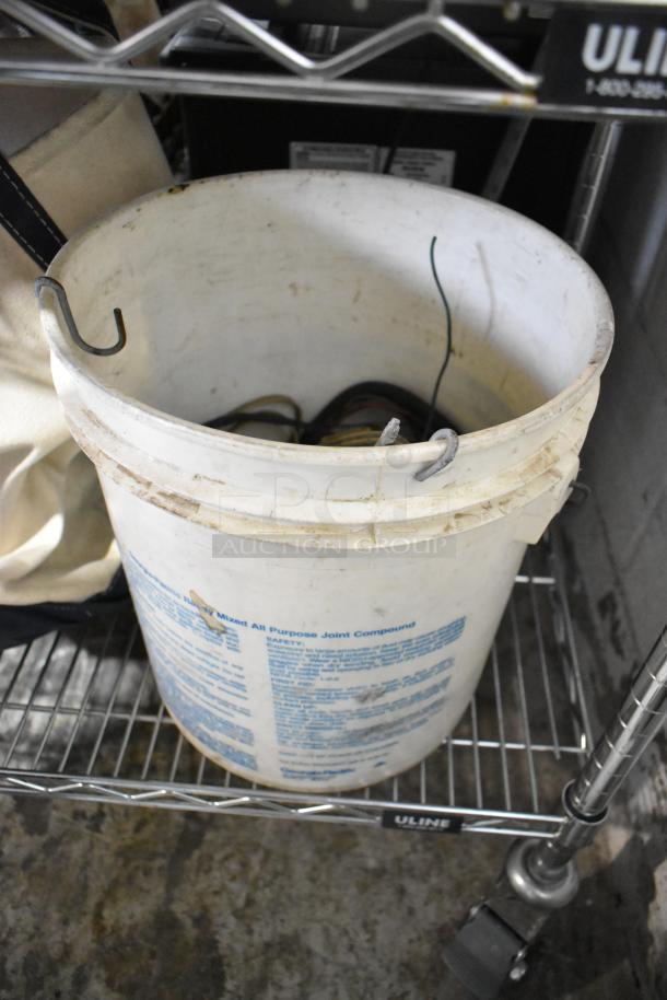 All-purpose joint compound bucket with wire hooks on metal shelf, part of mixed tier lot auction.