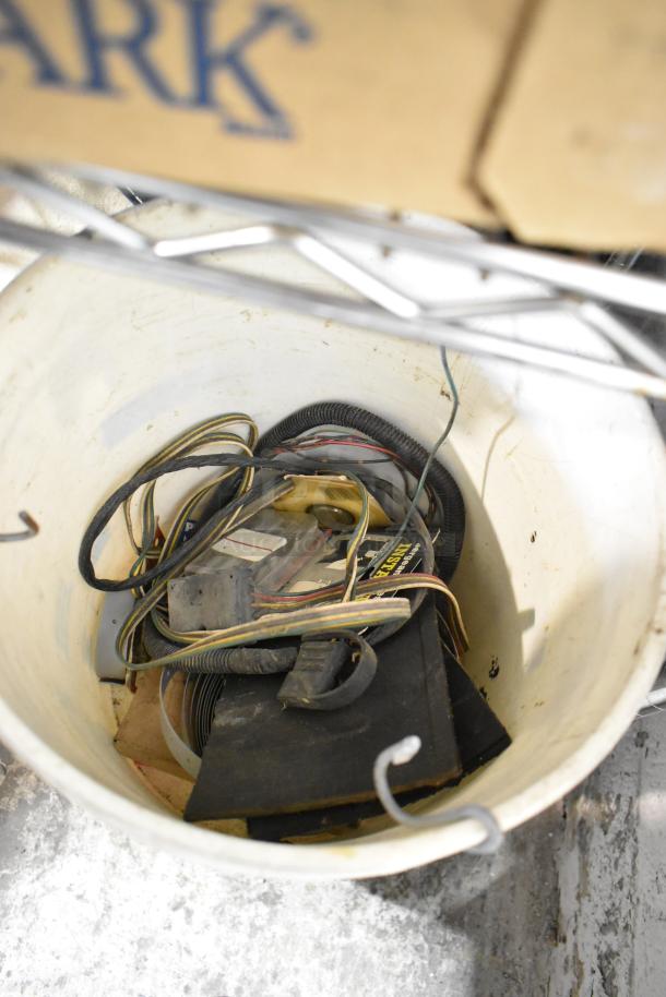 Bucket filled with assorted cables and electronic parts; no visible labels. Part of a mixed auction lot.
