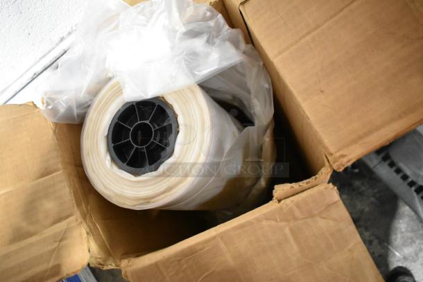 A roll of plastic sheeting in an open cardboard box, part of a tier lot including file folders, a doorknob, and outlet covers.