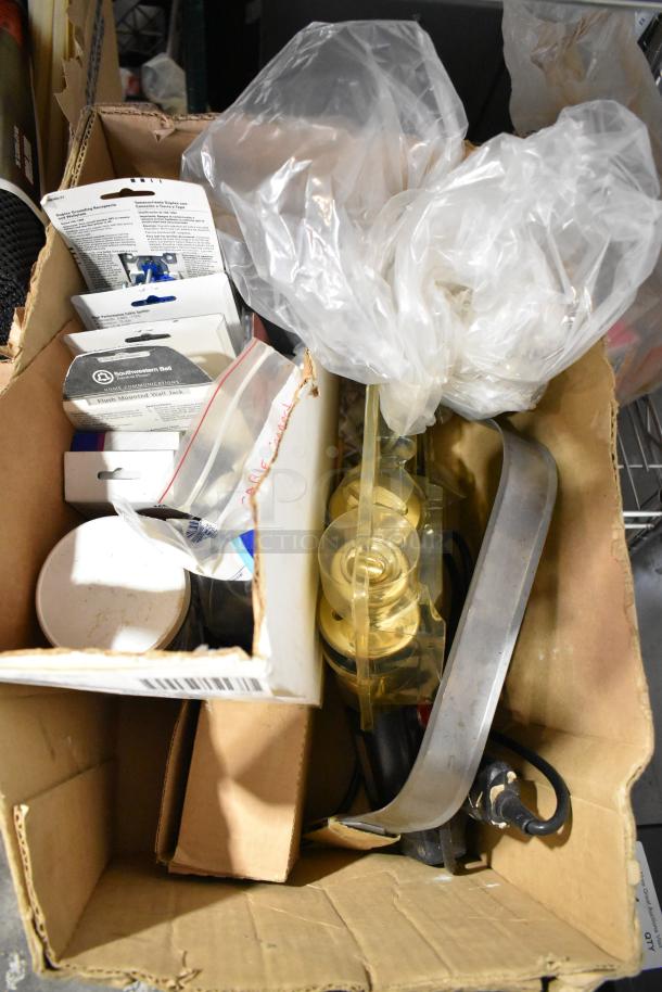 Box of assorted items including file folders, plastic sheeting, doorknob, outlet covers, and wall jack. Mixed condition.
