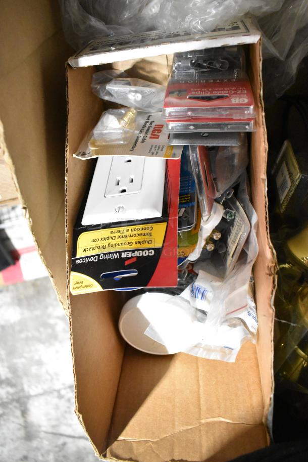 Box containing various items: file folders, Cooper Wiring Devices outlet, doorknob, outlet covers, and plastic sheeting.