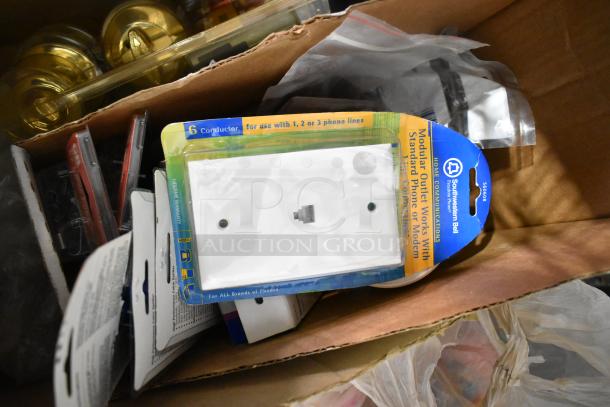 Auction item box with file folders, plastic sheeting, doorknobs, and Southwestern Bell outlet covers for phone lines.