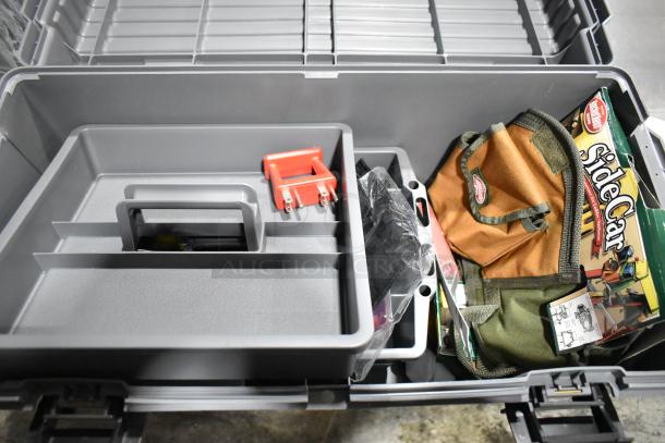 Gray poly tool box containing various items, including a Tru Rubber extension cord and an orange-brown tool pouch.