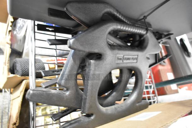 Tiered lot with black rubber extension cord holder and gray poly tool box, various items, Tru brand label visible.