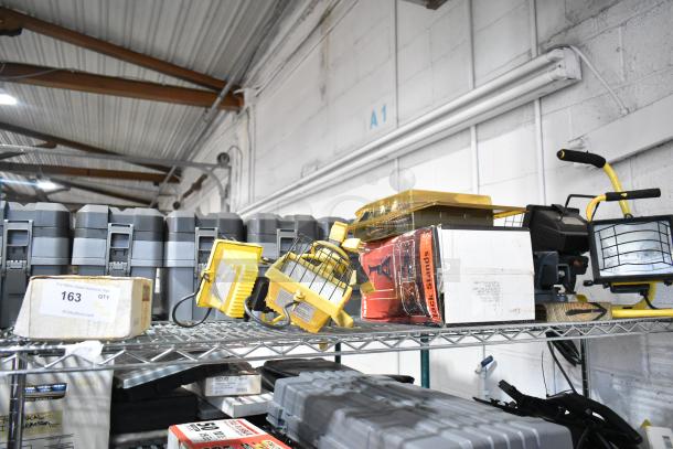 Tier lot of items including SM2262 magnetic base worklight, stretch net, jack stands. Mixed condition on metal shelf.