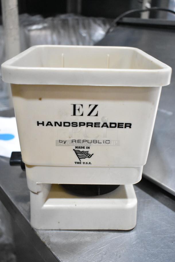 White EZ Handspreader by Republic, made in the USA, shown on a metal table. Appears in used condition with minor marks.