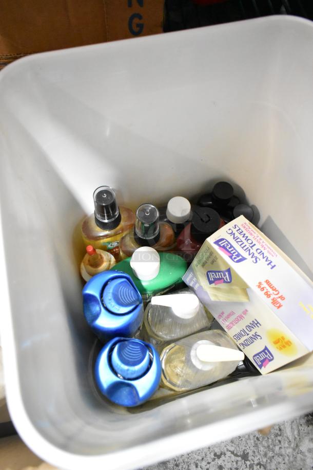 Tiered lot of various items in a bin including lubricants, sprays, and sanitizing hand towels. Mixed condition.