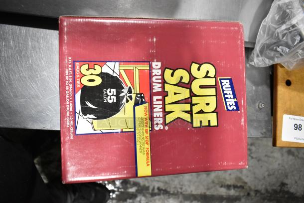 Box of Sure Sak Drum Liners, 55-gallon capacity, with rip stop formula, visible on a metal surface.