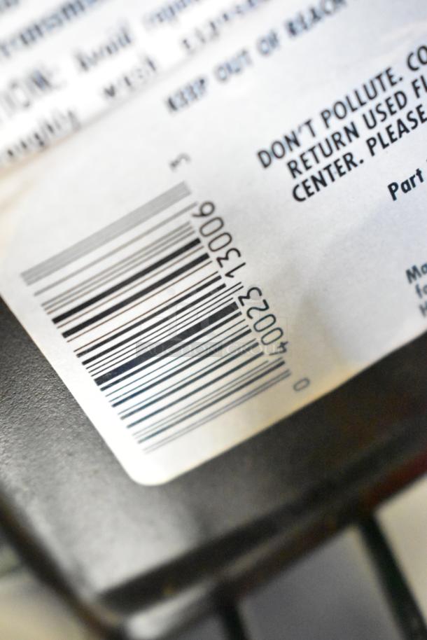 Close-up of a barcode and label text on an auction item, part of a lot including a Maytag air conditioner and other items.