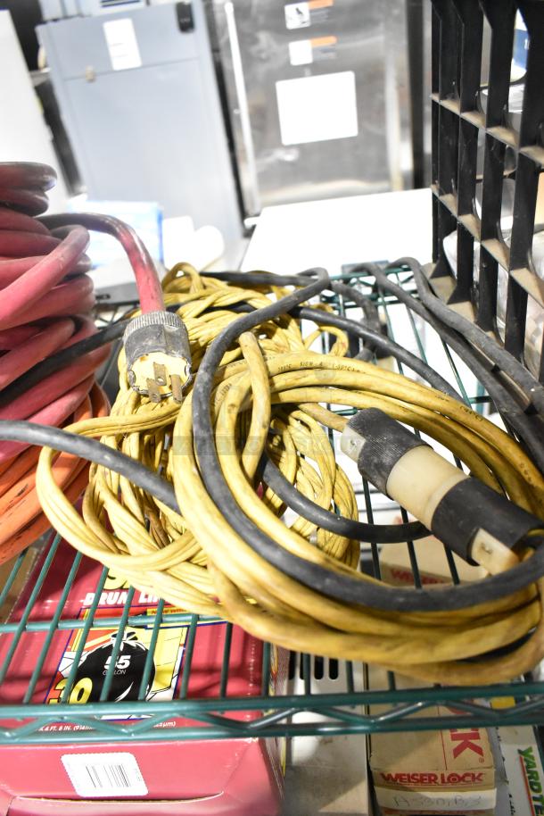 Assorted extension cords and Security Plus System 1000 alarm on a shelf. Includes packaging for various items.