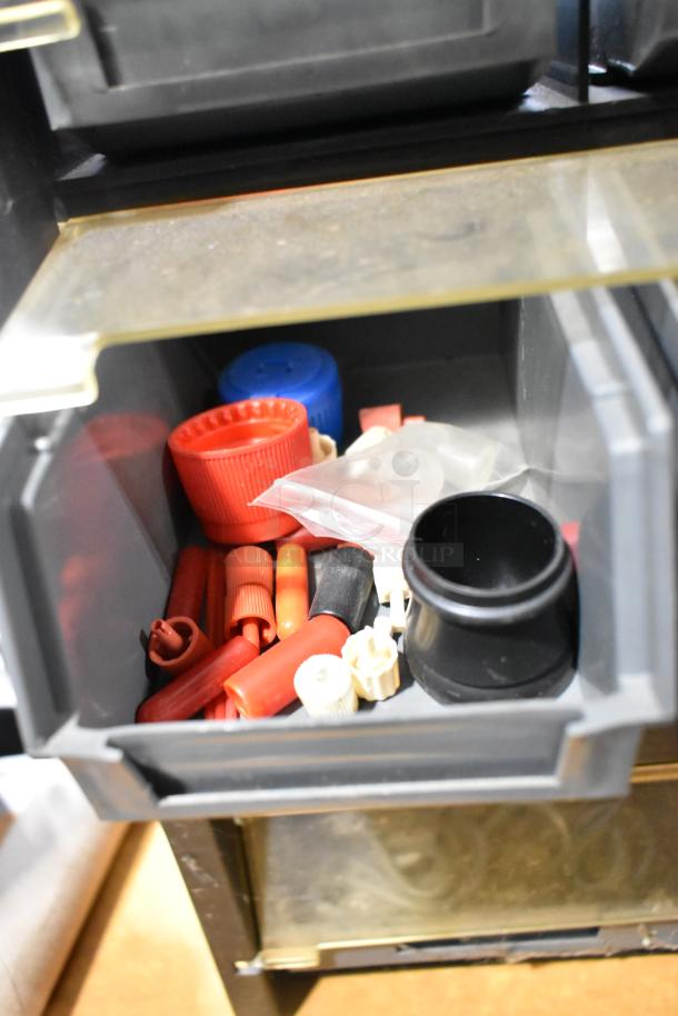 Poly hardware holder with bins containing various caps and connectors. Bins are gray with a transparent cover. Good condition.