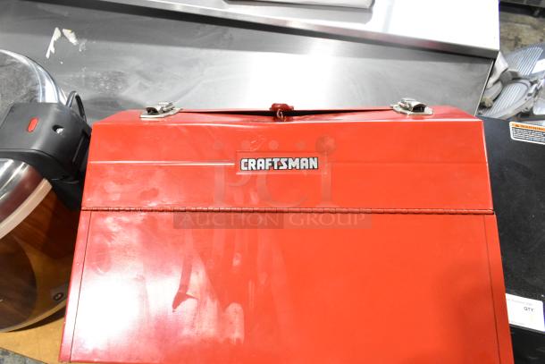 Red Craftsman metal tool box with contents, polished finish, dual latches, branded logo on front, good condition.