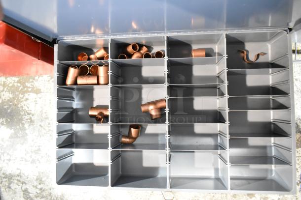 Gray metal 4-drawer hardware box with dividers, containing copper fittings; in good condition, ideal for organized storage.