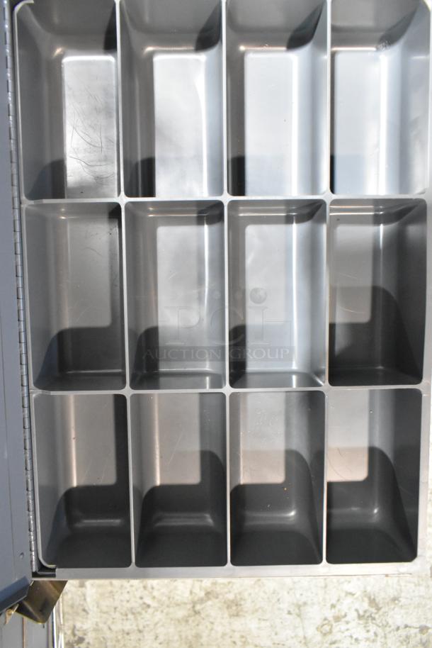 Gray metal 4-drawer hardware box with organized compartments, showing light wear. Ideal for tool storage and organization.