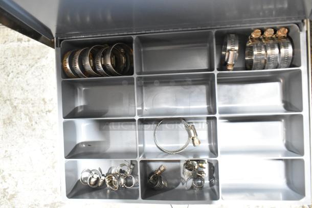 Gray metal 4 drawer hardware box with assorted metal clamps in compartments, showing good condition and organization.