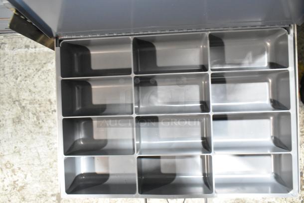 Gray metal 4-drawer hardware box with multiple compartments, showing empty storage space.
