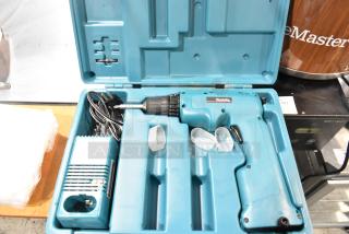 Makita electric drill in blue hard case, includes charger and accessories, well-maintained, ideal for professional use.