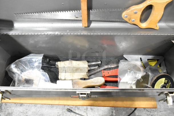 Craftsman gray metal toolbox with assorted tools, including saw blades, brushes, and hand tools; used condition.