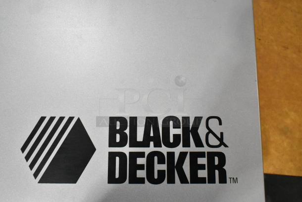 Black & Decker logo on gray metal tool box for an industrial electric power tool.