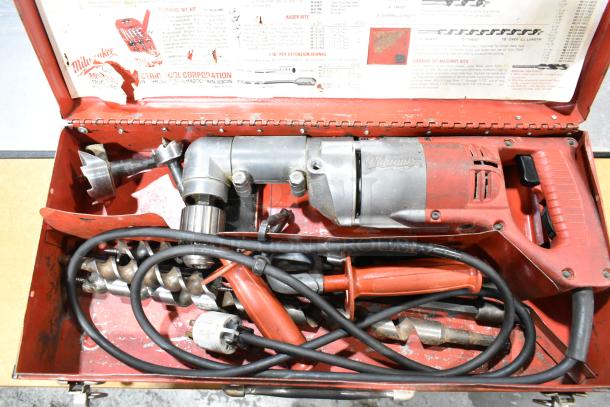 Milwaukee electric right angle drill in a red metal toolbox. Includes various drill bits and accessories. Vintage condition.