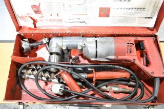 Milwaukee electric right angle drill in a red metal toolbox. Includes various drill bits and accessories. Vintage condition.