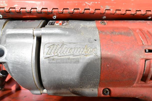 Milwaukee Electric Right Angle Drill in red metal tool box, visible logo and light wear, indicating used condition.