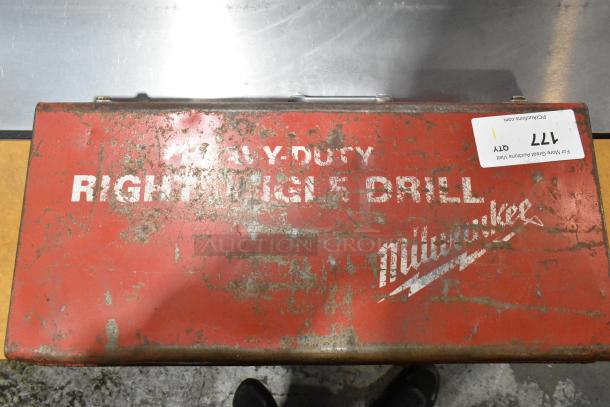 Milwaukee Electric Right Angle Drill in red metal tool box, shows visible wear, labeled "Milwaukee" and "Right Angle Drill".