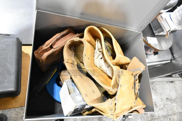 B&D gray metal box containing a tool belt, various tools, and supplies; shows well-used condition with sturdy design.