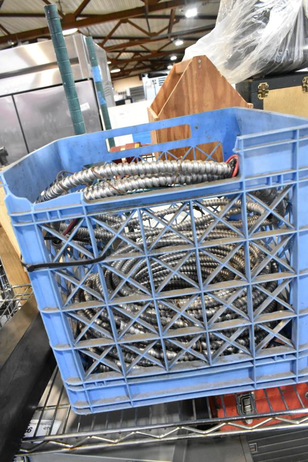 Blue poly crate with coiled metallic wires, used; part of a mixed lot including wires, gloves, and poly boxes for auction.