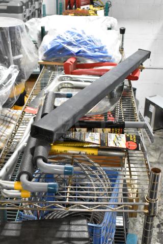Auction lot with various items on a metal rack, including a hose, Goldblatt panel carry, and wall storage hangers.