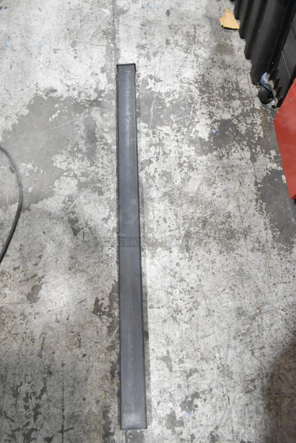 Various items including a hose, Goldblatt panel carry, and giant wall storage hangers on a concrete floor.