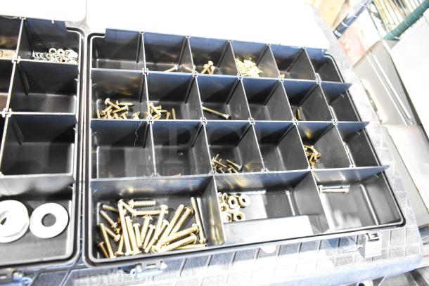 Black plastic tool box with multiple compartments containing assorted screws, nuts, and washers in good condition.