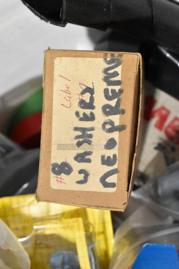 Cardboard box with handwritten label "Washers Neoprene" and "Label 1" in a toolbox. Contains various items.