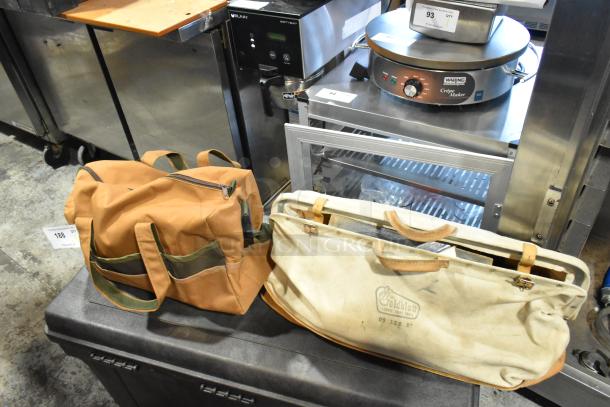 Two bags with contents including trowels; one canvas Goldblatt bag and one brown fabric bag with pockets; used condition.