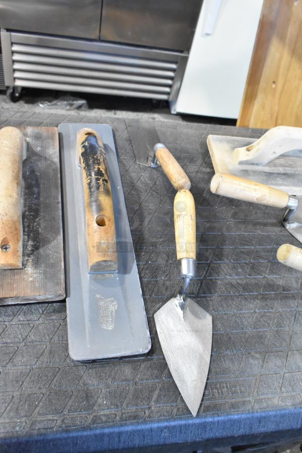 Two various bags with trowels, including wooden and metal handled tools, shown in used condition.
