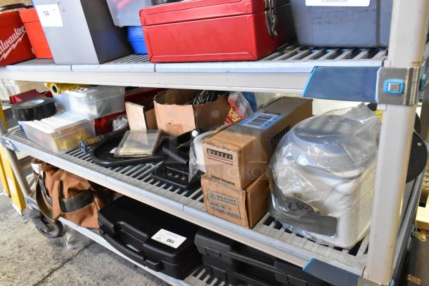 Tiered shelving with assorted items including red and gray toolboxes, poly bins, cardboard boxes labeled "Murray Circuit Breakers," and miscellaneous tools. Signs of light use, ideal for utility storage.
