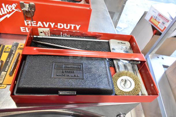 Craftsman 3/8" electric drill in Milwaukee red metal tool box, includes drill bits, wire brush, and replacement bits. Made in USA.