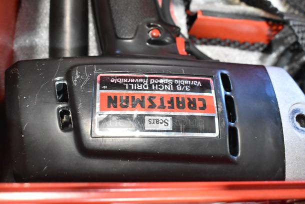 Craftsman 3/8 inch electric drill, variable speed, reversible, lightly used, in Milwaukee red metal tool box, label visible.