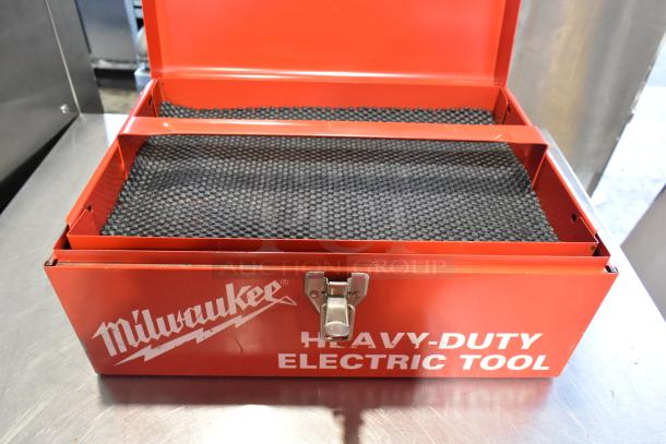 Milwaukee Electric Holeshooter in red metal tool box, open, showing black padded interior, "Heavy-Duty Electric Tool" text.