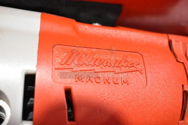 Milwaukee Electric Holeshooter, red casing with "Milwaukee Magnum" embossed, housed in a Milwaukee red metal tool box.
