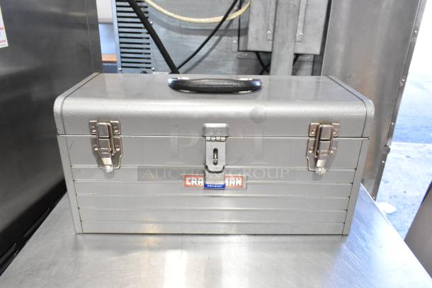 Gray Craftsman metal toolbox with contents, featuring durable latches and a carrying handle, includes a Skilsaw saw.