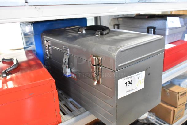 Two metal toolboxes with contents, including a Skilsaw saw. Visible labels indicate auction item number 194, quantity 2x.