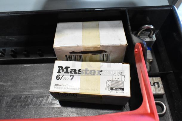 Two metal toolboxes with contents, including a Skilsaw saw and Master lock boxes, filled and labeled, indicating security hardware.