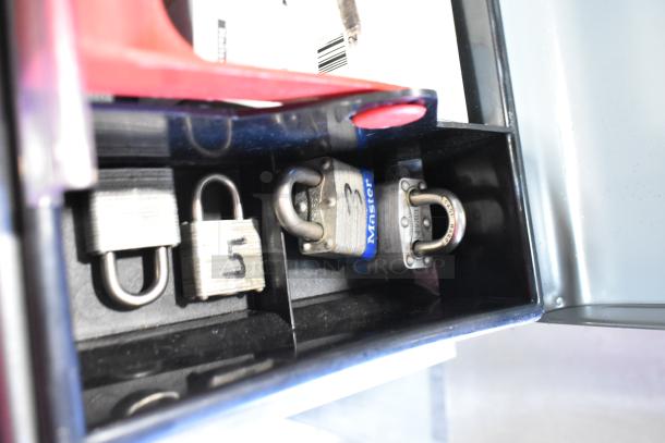 Two metal tool boxes containing locks and Skilsaw. Boxes show minor wear. Locks labeled with numbers.