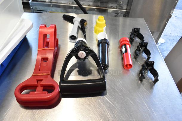 Two poly bins with contents including a red strap, various connectors, and a hole saw kit, displayed on a metal surface.