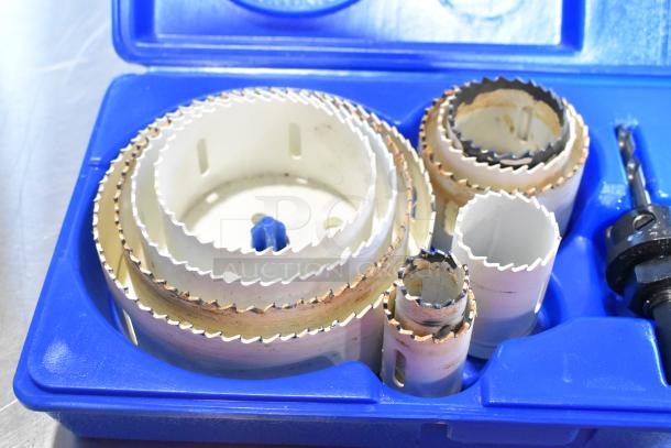 Hole saw kit in blue plastic case, contains multiple saw sizes with visible wear, suitable for varied drilling tasks.