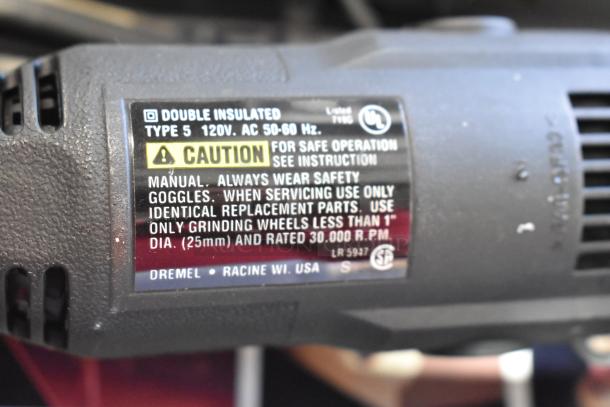 Dremel MultiPro drill label. Features: double insulated, variable speed, 120V, safety instructions. Item in gray case.